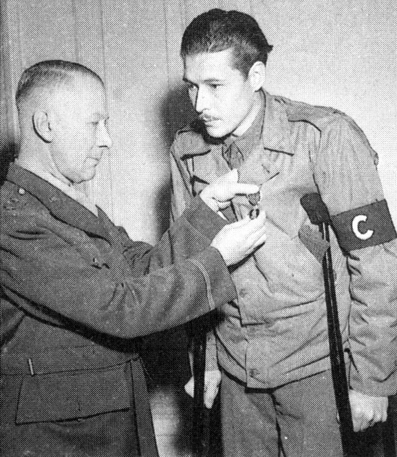 Major General Lloyd R. Fredendall, who later commanded the U.S. II Corps in Tunisia, pins a Purple Heart on correspondent Leo "Bill" Disher.