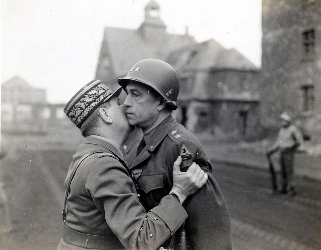 Major General Maurice Rose, commander of the 3rd Armored Division, receives the Croix de Guerre and an embrace from a French general in mid-March 1945.